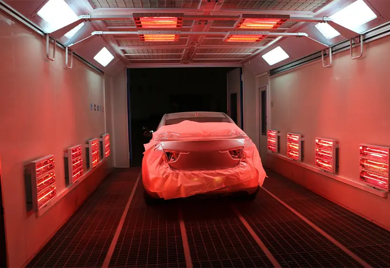 A car that has been painted in a paint booth for heat treatment